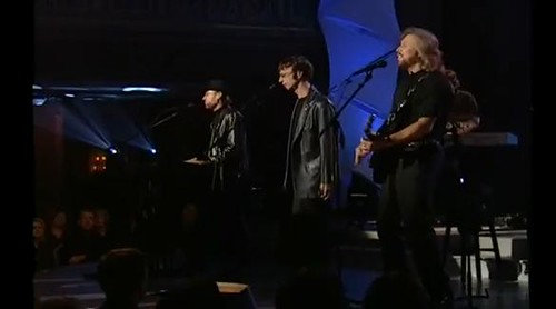 Immagine dei Bee Gees allineati su un palcoscenico durante un concerto (“Bee Gees Live” by bestgibb is licensed under CC BY-SA 2.0).