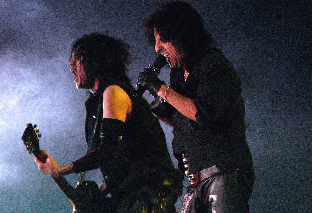 Immagine di Alice Cooper durante un concerto mentre canta reggendo il microfono con le mani guantate (“5. ALICE COOPER” by Hot Gossip1 is marked with CC BY-ND 2.0). La musica rock è una filosofia di vita.