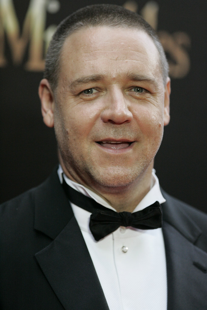 Immagine in primo piano di Russell Crowe sorridente in smoking (“Russell Crowe” by Eva Rinaldi Celebrity Photographer is marked with CC BY-SA 2.0). Il film è "A Beautiful Mind".