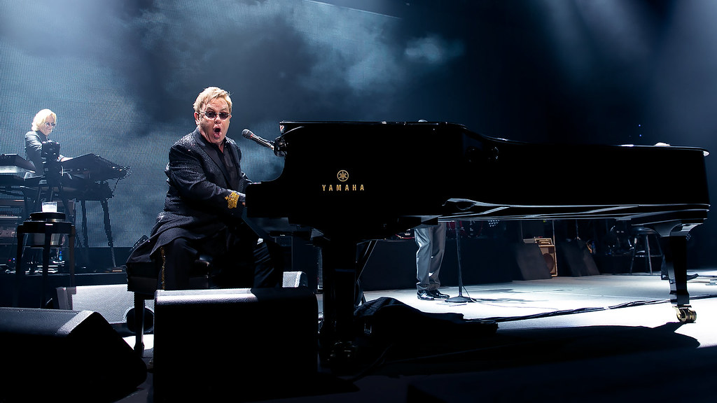 Immagine di Elton John ripreso seduto al pianoforte a coda durante un concerto ( “Sir Elton John, Oslo Spektrum 2014” by NRK P3 is licensed under CC BY-NC-SA 2.0). La musica rock è una filosofia di vita.