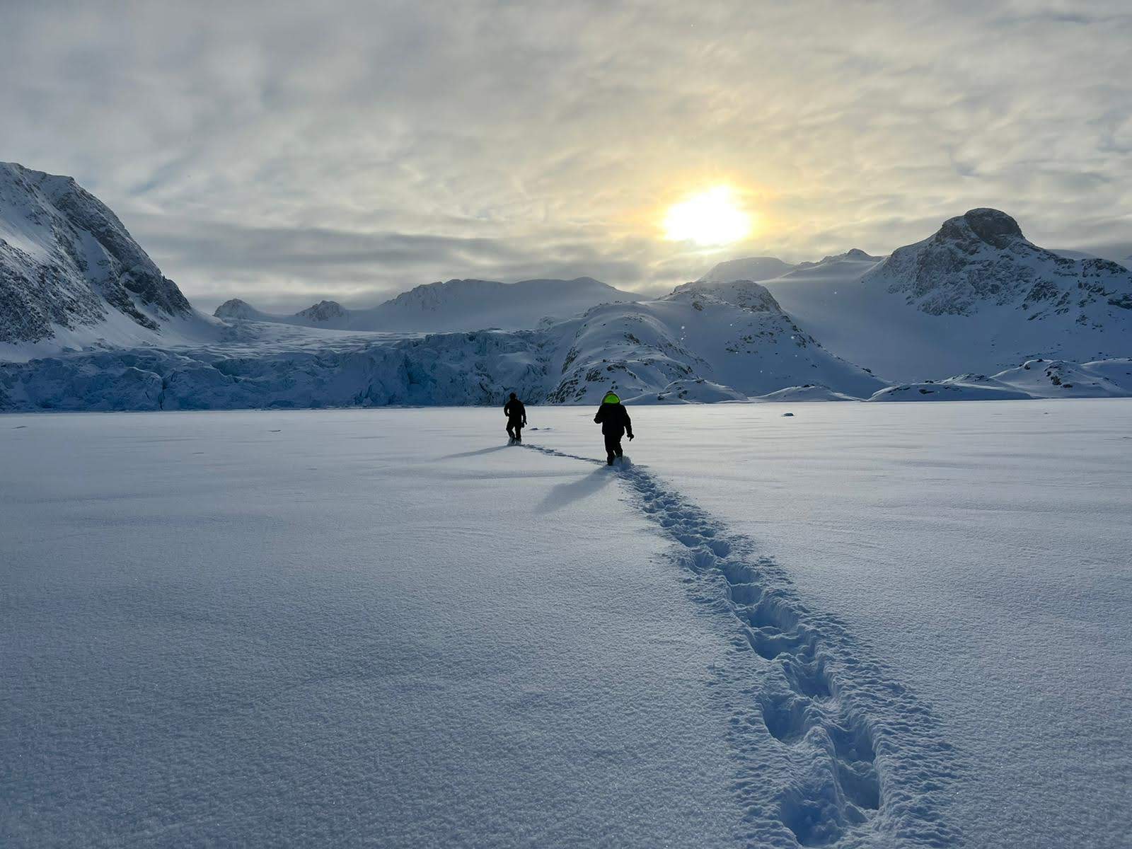 Immagine di due esploratori visti di spalle mentre avanzano nella neve in uno scenario polare. La retorica (rhetorike) non è solo fumo: lascia tracce ben visibili nel mondo. Altro cosa è vedere se conduce alla verità.