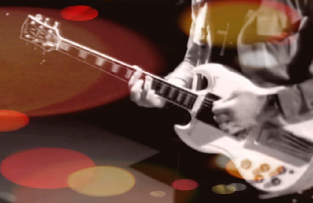 Immagine "psichedelica" di una chitarra elettrica bianca mentre viene suonata da un musicista del quale si vedono solo le mani e una parte anteriore del busto. Filosofia di vita rock stoica è resistere alla rincorsa delle mode per mantenere lo spirito originario del rock quale forma di ribellione alle convenzioni e alle ipocrisie del perbenismo. Photo by Paola Gatti.
